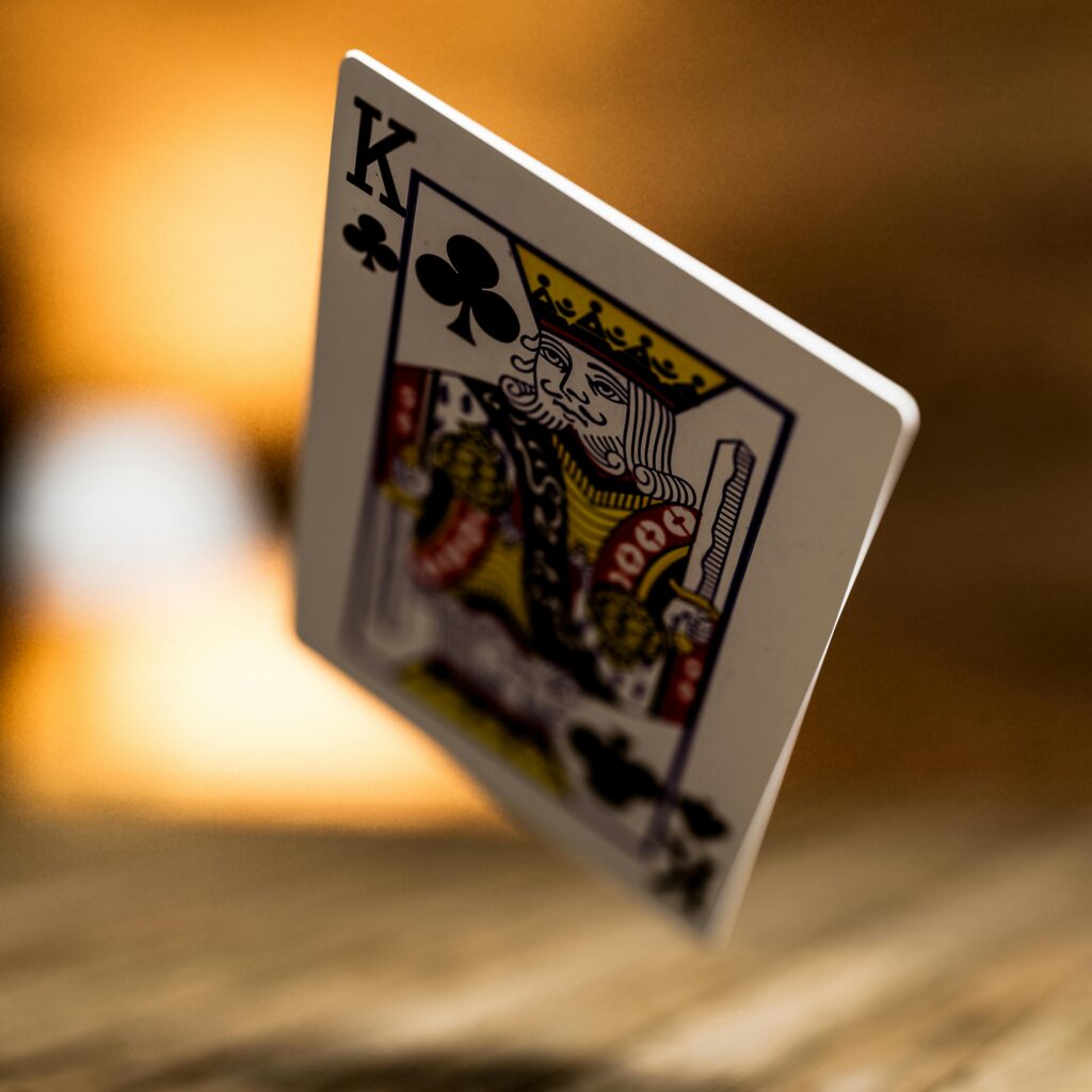 Artistic close-up of the King of Clubs playing card with blurred background.